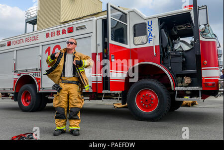 Il personale Sgt. Kyle Wirth, 374 Ingegnere Civile squadra antincendio e di soccorso Flight Crew Chief, mette su indumenti protettivi a Yokota Air Base, Giappone, 28 marzo 2016. Wirth ha utilizzato la marcia per proteggere se stesso durante la simulazione di una estrazione del veicolo, un esercizio che prevede il taglio di pezzi da un veicolo e rottura correttamente windows per estrarre un crash vittima senza ferire loro. (U.S. Air Force foto di Airman 1. Classe Elizabeth Baker/rilasciato) Foto Stock