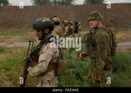 Un soldato Australiano, Assegnato a gruppo attività Taji, valuta soldati iracheni con 4° Battaglione, XXIII esercito iracheno brigata, sulla loro capacità di pattugliamento per una valutazione delle competenze presso il Camp Taji, Iraq, 28 marzo 2016. Gruppo di attività condotte Taji la valutazione delle competenze per valutare i soldati proficiency in base attività di combattimento. Attraverso la consulenza e assistenza e la costruzione di capacità del partner missioni, la Combined Joint Task Force - Funzionamento inerenti risolvere la coalizione multinazionale ha addestrato più di 19.9K personale per sconfiggere lo Stato islamico dell Iraq e il levante. (U.S. Esercito foto di Sgt. Paolo Vendita/Relea Foto Stock