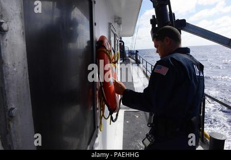 Petty Officer 2a classe Angel Carballo, una di boatswain mate e imbarco membro della squadra di USCGC Kukui (WLB 203), ispeziona un anello di vita durante un a-mare di salire a bordo di una nave da pesca nell'Oceano Pacifico, 30 marzo 2016. L'equipaggio di Kukui è attualmente in corso con la del Pacifico centrale e occidentale conduce una applicazione della legge e la pesca patrol. (U.S. Coast Guard foto di Sottufficiali di 2a classe di Melissa E. McKenzie/rilasciato) Foto Stock