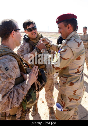 Un soldato iracheno, diritto, assegnato al settimo esercito iracheno divisione, imposta un'antenna con l'assistenza di U.S. Marines durante il corso di formazione sulla radio UHF operations di Al Asad Air Base, Iraq, 30 marzo 2016. Comunicazione formazione è solo una delle competenze insegnate al Asad come parte della costruzione di capacità del partner di missione, che aumenta la capacità militari delle Forze di Sicurezza Irachene a combattere lo Stato islamico dell Iraq e il levante. Abilitando ISF attraverso consigliare e assistere e missioni di BPC, la Combined Joint Task Force - Funzionamento inerenti risolvere la coalizione multinazionale è aiutare i Foto Stock