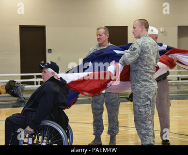 SIOUX FALLS, S.D. - Capo Comandante Sergente. Michael Dellman, 114Mission Support Group Chief, e suo figlio, Staff Sgt. Andrew Dellman, 114Fighter Wing tecnico contabile, insieme con gli altri membri della 114Fighter Wing e reduci dal VFW e American Legion ha presentato una grande bandiera americana a NCAA donna gioco di basket in Sanford Pentagono, Sioux Falls, S.D. Mar 23, 2016. Elementi unitari spesso volontario per presentare la bandiera prima di eventi sportivi nella zona locale per mostrare il loro sostegno alla comunità e a promuovere il patriottismo. (U.S. Air National Guard foto di Senior Master Sgt. Nancy Ausl Foto Stock