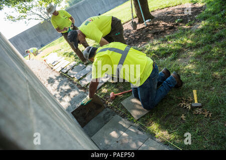 Volontari raddrizzare, livello e sostituire le pietre rotte al di fuori della Corte Columbarium 1 presso il Cimitero Nazionale di Arlington Arlington, Virginia, 16 luglio 2018. Oltre 400 volontari professionisti del paesaggio ha partecipato in Associazione Nazionale dei professionisti del paesaggio' xxii rinnovo annuale e ricordo evento presso il Cimitero Nazionale di Arlington. Volontari aerato turf, piantato fiori, di cui i tubi di irrigazione e illuminazione installata una protezione su diversi alberi. (U.S. Foto dell'esercito da Elizabeth Fraser / il Cimitero Nazionale di Arlington / rilasciato) Foto Stock