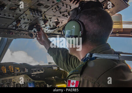 180715-O-N0842-2010 OCEANO PACIFICO (15 luglio 2018) Royal Canadian Air Force Caporale David Bettle, un tecnico di volo con un canadese Aurora (CP 140) aeromobile, regola i controlli nella cabina di pilotaggio durante il volo come parte di una sub-caccia scenario durante il cerchio del Pacifico (RIMPAC) esercizio. Venticinque nazioni, 46 navi, cinque sommergibili, circa 200 aerei e 25.000 personale partecipano RIMPAC dal 27 giugno al 2 agosto in e intorno alle Isole Hawaii e la California del Sud. Il più grande del mondo marittimo internazionale esercitazione RIMPAC offre una singolare opportunità di formazione mentre la promozione Foto Stock