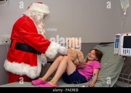 180714-N-IY469-071 - Santa Claus fornisce Alessandria un giocattolo durante il Rolling Thunder Natale in luglio. Queste moto club membri NMCP visita due volte l'anno, visitando i bambini in pediatria Ward, pediatrici di unità di cure intensive e sala di emergenza. Santa Claus mani presenta per ogni bambino riceve cure mediche. (U.S. Foto di Marina di Massa lo specialista di comunicazione 1a classe Laura A. Myers/rilasciato) Foto Stock
