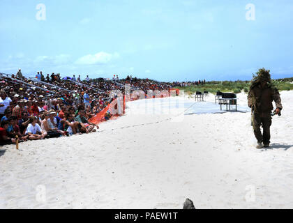 Spiaggia, Va. (luglio. 21, 2012) un Navy SEAL sniper onde per la folla dopo che mostra la sua posizione nascosta durante un esercizio di capacità in corrispondenza della giunzione base Expeditionary poco Creek-Fort Storia durante la xliii annuale demolizioni subacquee Team (UDT)-mare, l aria e la terra (guarnizione di tenuta) East Coast Reunion. La riunione annuale avviato nel 1969 e si è espansa in un fine settimana di eventi, concorsi e una capacità di tenuta di esercizio. Foto Stock