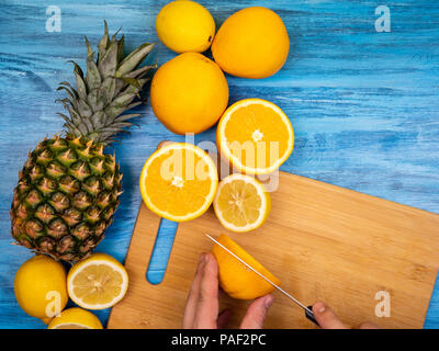 Ananas, arance in appoggio su una tavola di legno Foto Stock