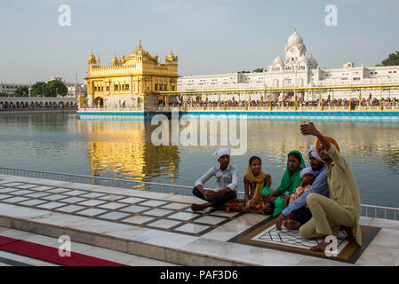 Famiglia indiana che scatta un selfie sullo sfondo del Tempio d'Oro ad Amritsar, Tempio Sikh Pujab India, giugno 2018 Foto Stock