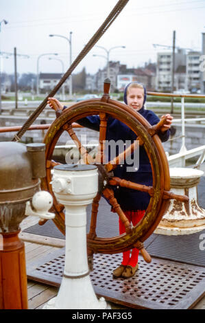 Giovane ragazza sul ponte volante della nave su una storica barca negli anni '60 Foto Stock