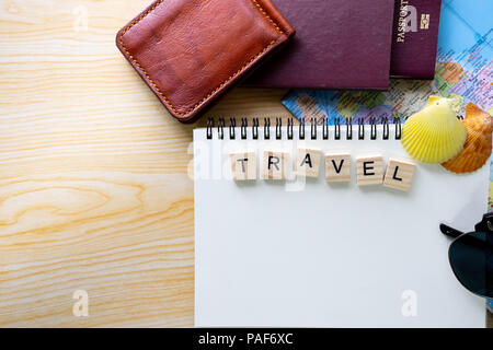 Piatto estivo laici parole scritte su legno blocco di Scrabble e accessori da viaggio su sfondo giallo con uno spazio vuoto per il testo. Vista dall'alto di viaggio o vaca Foto Stock