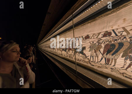 Bayeux, Francia. Visitorswalk passato il famoso arazzo (Tapisserie) di Bayeux,1000 anno moquette vecchia che racconta la storia della conquista normanna di Inghilterra Foto Stock