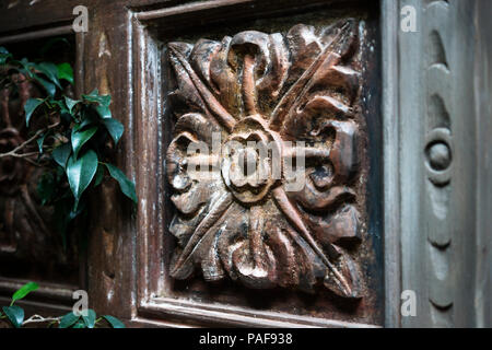 Dettaglio di un fiore in legno carving con verde scuro impianto in La Orotava, Tenerife, Isole Canarie, Spagna Foto Stock