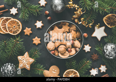 Anno nuovo o scatola di Natale con dolci Gingerbread cookies, panpepato stelle, essiccato anelli arancioni e abete. Vista dall'alto. Piatto di Natale compositio laici Foto Stock