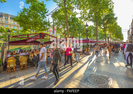 Parigi, Francia - luglio 2, 2017: turisti passeggiata sul viale più famoso di Parigi, gli Champs Elysees, per fare shopping in negozi di lusso. Stile di vita delle persone sedute al Cafe George V. Foto Stock