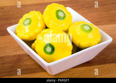 Piccole dimensioni patty pan patisson squash closeup Sfondo legno Foto Stock