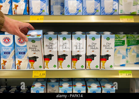 Imballaggi die faire Milch stampati con vacche bandiera tedesca in un negozio tedesco Foto Stock