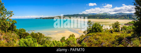 Immagine panoramica con vista sulla baia sabbiosa verso Marahau sul Abel Tasman via, Nuova Zelanda, con bel cielo azzurro e la spiaggia di sabbia fine e dorata Foto Stock