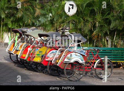 YOGYAKARTA - 03 agosto: rikshaw tradizionale trasporto su strade di Yogyakarta, Java, in Indonesia il 03 agosto 2010. Noleggio rikshaw rimane più di me Foto Stock