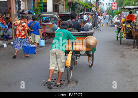 YOGYAKARTA - 03 agosto: rikshaw tradizionale trasporto su strade di Yogyakarta, Java, in Indonesia il 03 agosto 2010. Noleggio rikshaw rimane più di me Foto Stock