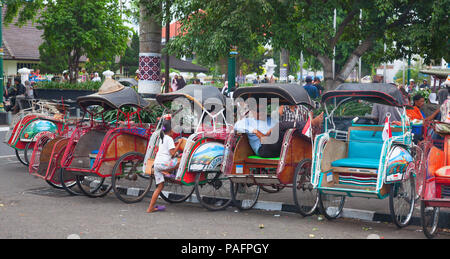 YOGYAKARTA - 03 agosto: rikshaw tradizionale trasporto su strade di Yogyakarta, Java, in Indonesia il 03 agosto 2010. Noleggio rikshaw rimane più di me Foto Stock