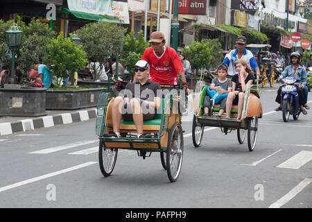 YOGYAKARTA - 03 agosto: rikshaw tradizionale trasporto su strade di Yogyakarta, Java, in Indonesia il 03 agosto 2010. Noleggio rikshaw rimane più di me Foto Stock