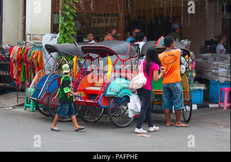 YOGYAKARTA - 03 agosto: rikshaw tradizionale trasporto su strade di Yogyakarta, Java, in Indonesia il 03 agosto 2010. Noleggio rikshaw rimane più di me Foto Stock