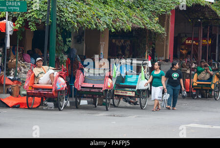 YOGYAKARTA - 03 agosto: rikshaw tradizionale trasporto su strade di Yogyakarta, Java, in Indonesia il 03 agosto 2010. Noleggio rikshaw rimane più di me Foto Stock