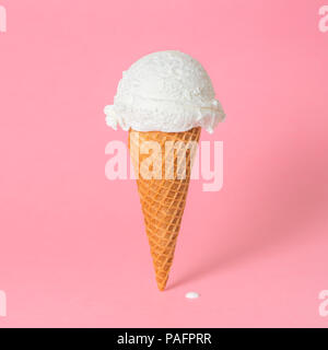 Estate divertente concetto creativo del cono di wafer con ghiaccio fondente crema su sfondo rosa, spazio di copia Foto Stock