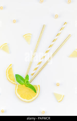 Creative overhead flatlay vista dall'alto di agrumi fette di limone e menta erbe Lascia tavolo bianco sfondo con copyspace. Estate calda limonata ristoro co Foto Stock