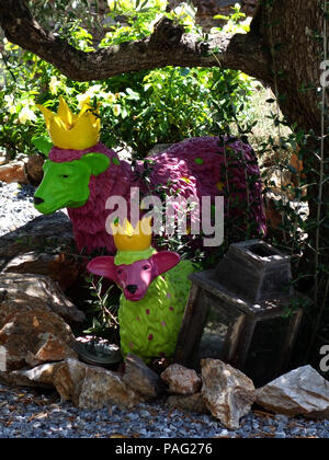 Due dipinto luminosamente scultptures di ovini sotto l'ombra di una struttura ad albero in una meravigliosa casa francese vicino a Magalas Languedoc-Roussillon, Francia Foto Stock