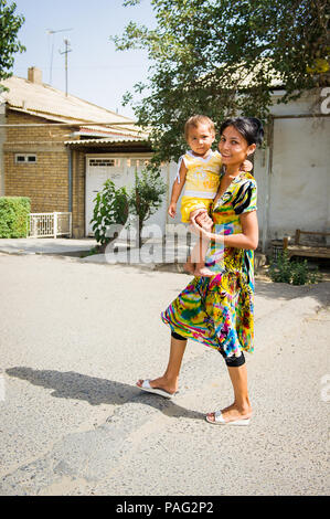 BUKHARA, UZBEKISTAN - 7 giugno 2011: Non identificato donna uzbeka passa per una passeggiata con il suo bambino in Uzbekistan, giu 7, 2011. Il 81% delle persone in Uzbekistan belo Foto Stock