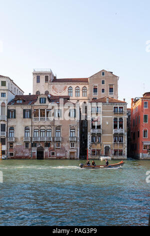 Locale famiglia veneziana facendo un giro in barca sul Gran Canal, Venezia, Veneto, Italia al tramonto durante l ora d'oro passando palazzi (palazzi) a San Marc Foto Stock