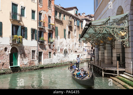 Gondola con felici turisti asiatici sul Rio de la veste dietro il Teatro La Fenice e il teatro lirico con ornati in ferro battuto, San Marco, Venezia, Venet Foto Stock