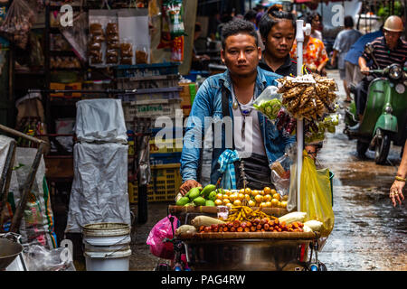 Bangkok, Tailandia - 1 Maggio 2018 :: il giovane uomo che porta un carrello pieno di cibo di strada per le strade di Bangkok Foto Stock