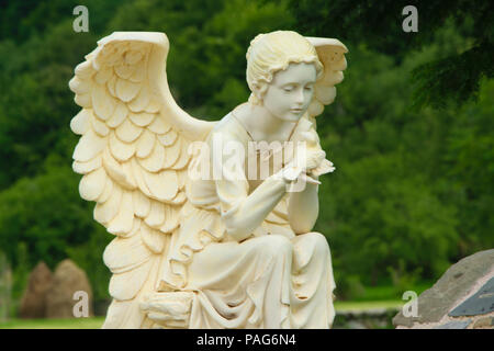 La scultura in marmo di angelo femmina seduti sulla roccia e tenendo un uccello nelle sue mani, Albania, Europa Foto Stock