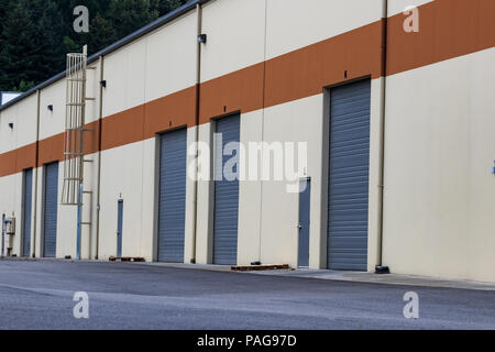 Magazzino edificio industriale porte garage e di un parcheggio Foto Stock