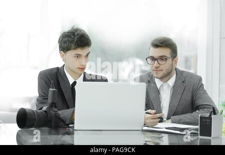 Fotografi qualificati discutere le foto per caricare i file su un computer portatile . Foto Stock