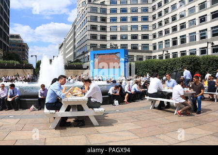 Londra. Regno Unito. Il 23 luglio 2018. Città i lavoratori godono di loro lunchbreak in estate il sole in Cabot Square, canry Wharf con temperature attese per raggiungere 35C di questa settimana e la Met Office emette un Ambra avviso meteo per le parti della Gran Bretagna colpita dall'attuale ondata di caldo Credito: amer ghazzal/Alamy Live News Foto Stock