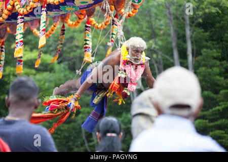 Val-Morin, Canada, 22 luglio 2018. Un devoto indù è sospesa per mezzo di ganci piercing la sua pelle al festival Kaavadi in Val Morin, Quebec. Centinaia di devoti indù riuniti per l annuale celebrazione del Signore Subramanya (o Muruga), il dio indù della guerra. Molti devoti sono sospese mediante ganci mentre aghi di perforazione sono la loro pelle come un modo per mostrare la penitenza e trascendenza. Altri devoti portano kaavadis (arcate ornate con penne di pavone) sulle loro spalle, come si è creduto che sono ottimi conduttori di energia spirituale. Credito: Cristian Mijea/Alamy Live News. Foto Stock