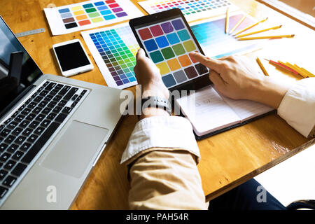 Graphic Designer utilizzano la tavoletta per scegliere i colori dal bar esempio per le idee di design, design creativo del designer di grafica concetto. Foto Stock