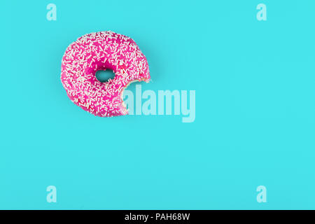 Il minimalismo, contrasto di colore su uno sfondo blu, donut foto da sopra in uno stile piatto Foto Stock