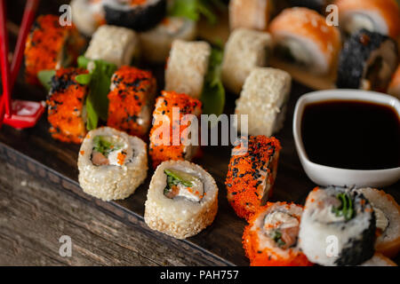 Sushi set foto di cibo. Rotoli servita su legno marrone e piastra di ardesia. Close up di sushi. Foto Stock