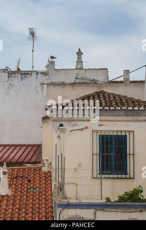 Dettaglio della vecchia abitazione tradizionali case portoghese. Tipici tetti in tegole e camini. Cielo nuvoloso. Lagos, Algarve, Portogallo. Foto Stock