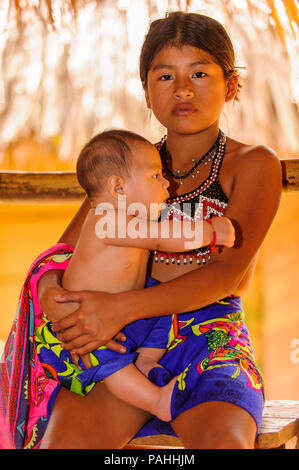 EMBERA VILLAGE, PANAMA, 9 gennaio 2012: Unidentified nativo ragazza indiana mantiene la sua sorellina in Panama, Jan 9, 2012. Indiano prenotazione è il modo in cui Foto Stock