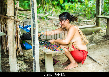 AMAZONIA, Perù - Nov 10, 2010: Amazzonica Non identificato donna indigena vende souvenir per i turisti. I popoli indigeni dell'Amazzonia sono protetti da Foto Stock