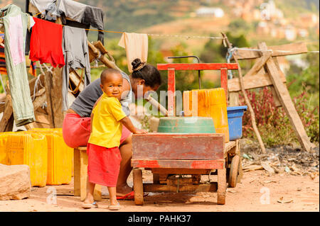 ANTANANARIVO, MADAGASCAR - Giugno 30, 2011: Unidentified Madagascar donna e suo figlio aiuta il suo lavoro. Persone in Madagascar soffrono di povertà dovuta a t Foto Stock