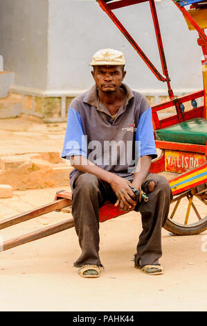 ANTANANARIVO, MADAGASCAR - Giugno 30, 2011: Madagascar non identificato uomo attendere per consentire al client di effettuare. Persone in Madagascar soffrono di povertà a causa della lenta Foto Stock