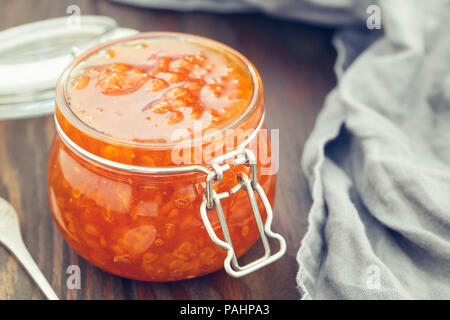 Vaso di vetro con cloudberry inceppamento. Cucina nordica. Foto Stock