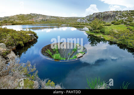 L'uomo ha fatto imbuto nel mezzo di un lago di montagna Foto Stock