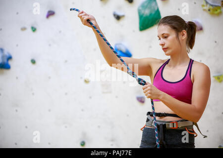 Close-up foto della ragazza scalatore con corda di sicurezza in mani alla Sports Hall Foto Stock