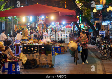 Night Shot di una delle tante strade trafficate che comprendono Hanoi il Mercato Notturno nel vecchio quartiere, Vietnam. Il popolare mercato avviene sul weekend e Foto Stock